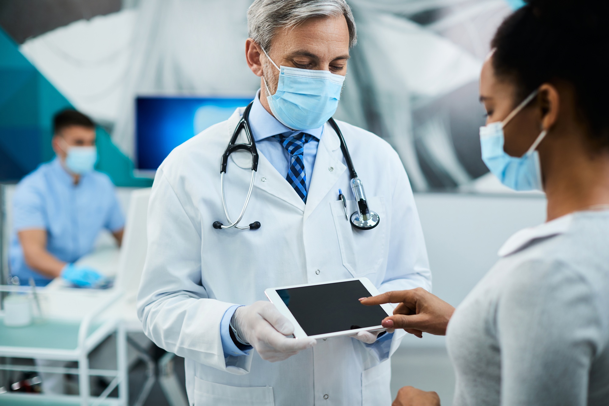 African American patient signing on touchpad after dental appointment with her dentist.