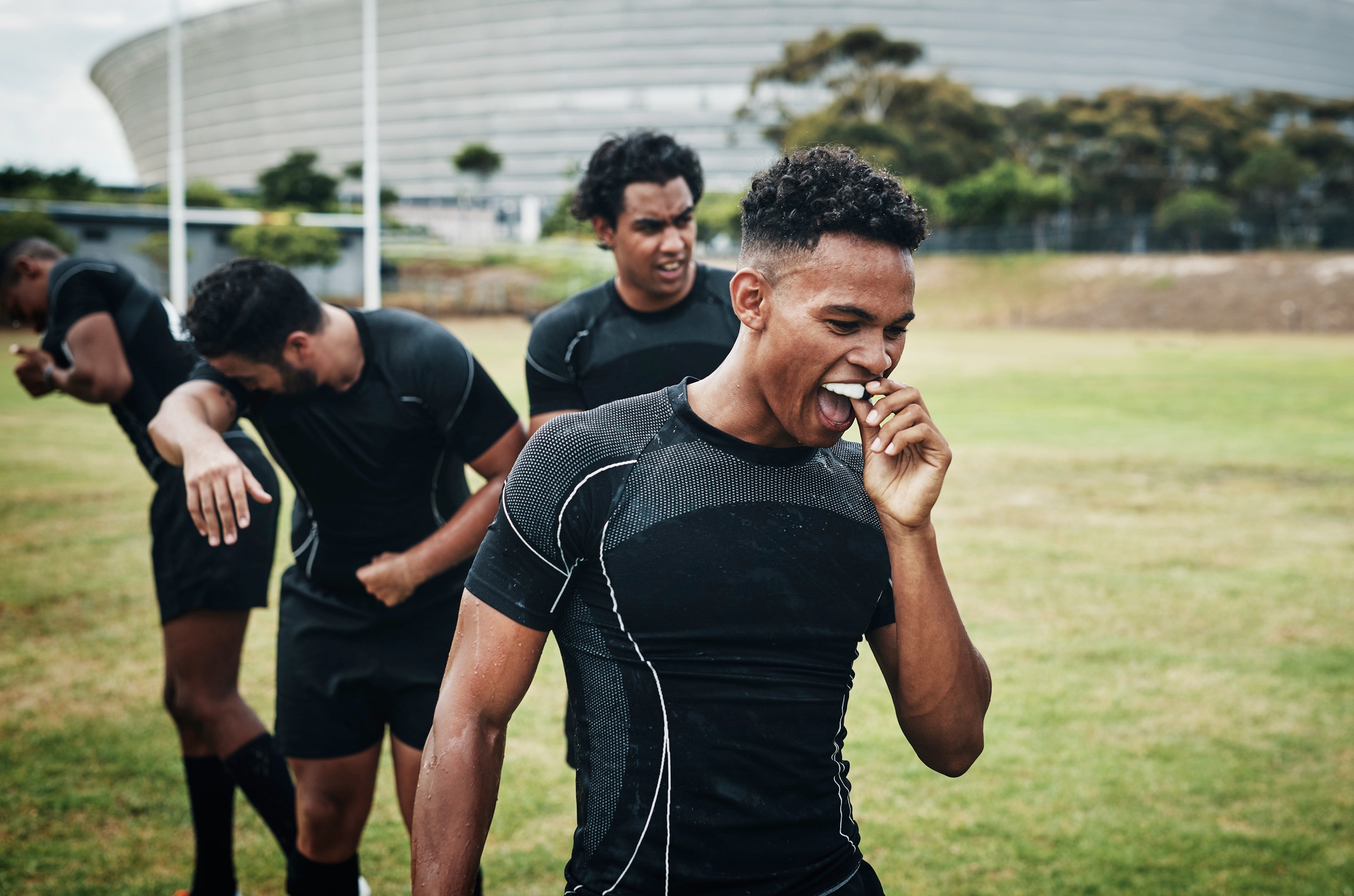 Cropped shot of a handsome young rugby player removing his mouthguard during half-time on the field