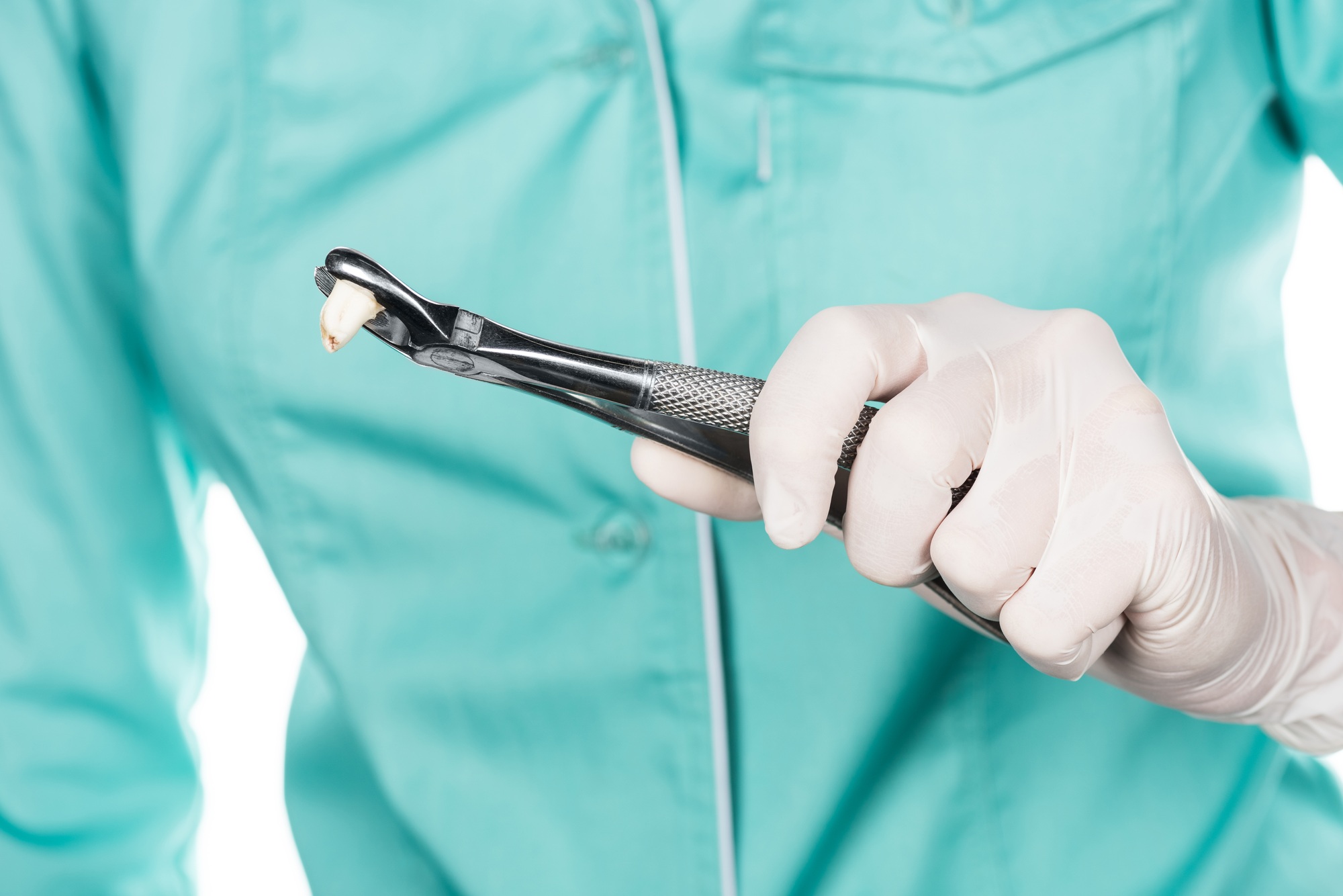 cropped shot of professional dentist holding tweezers with denture