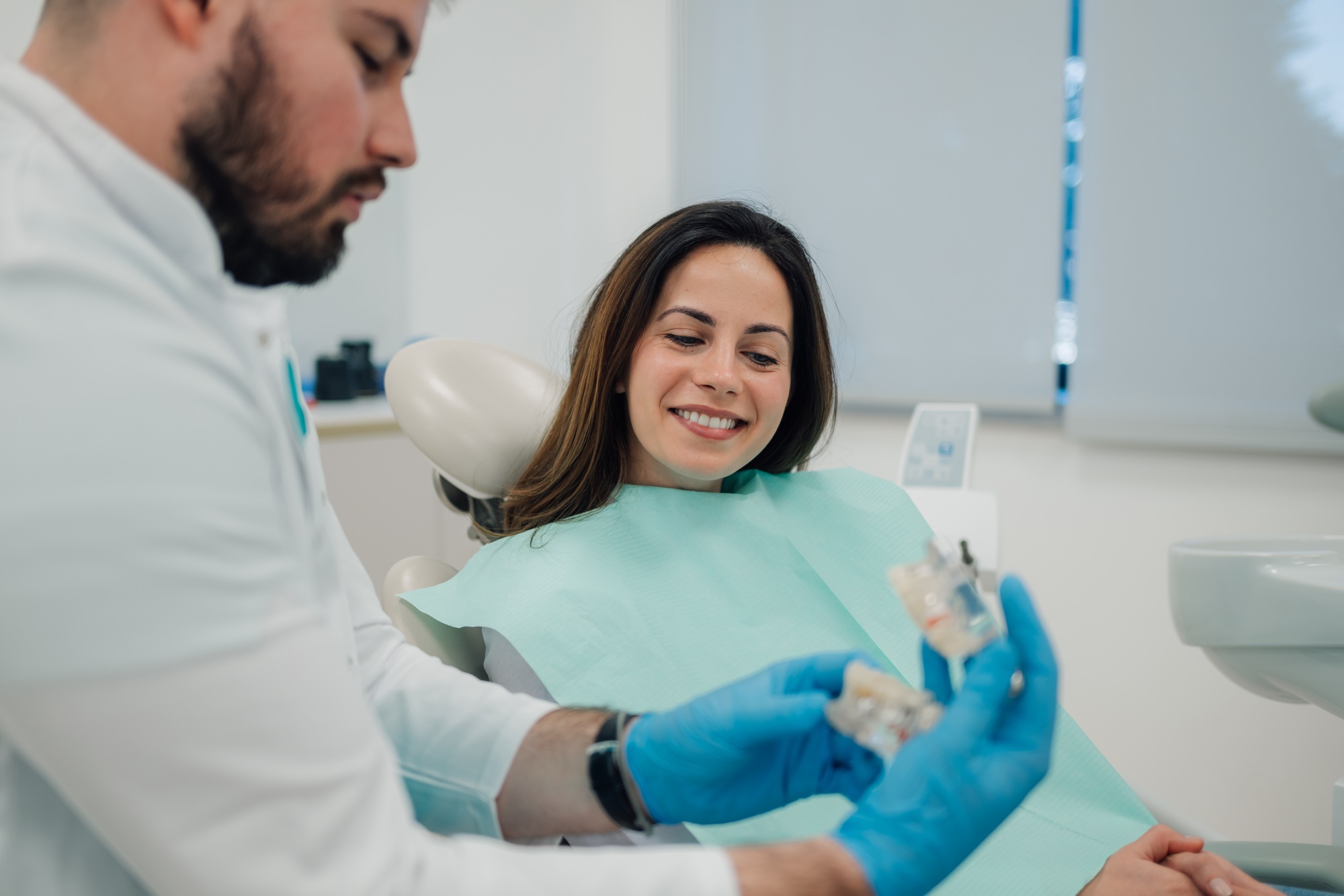 Dentist showing dentures to patient in dental clinic