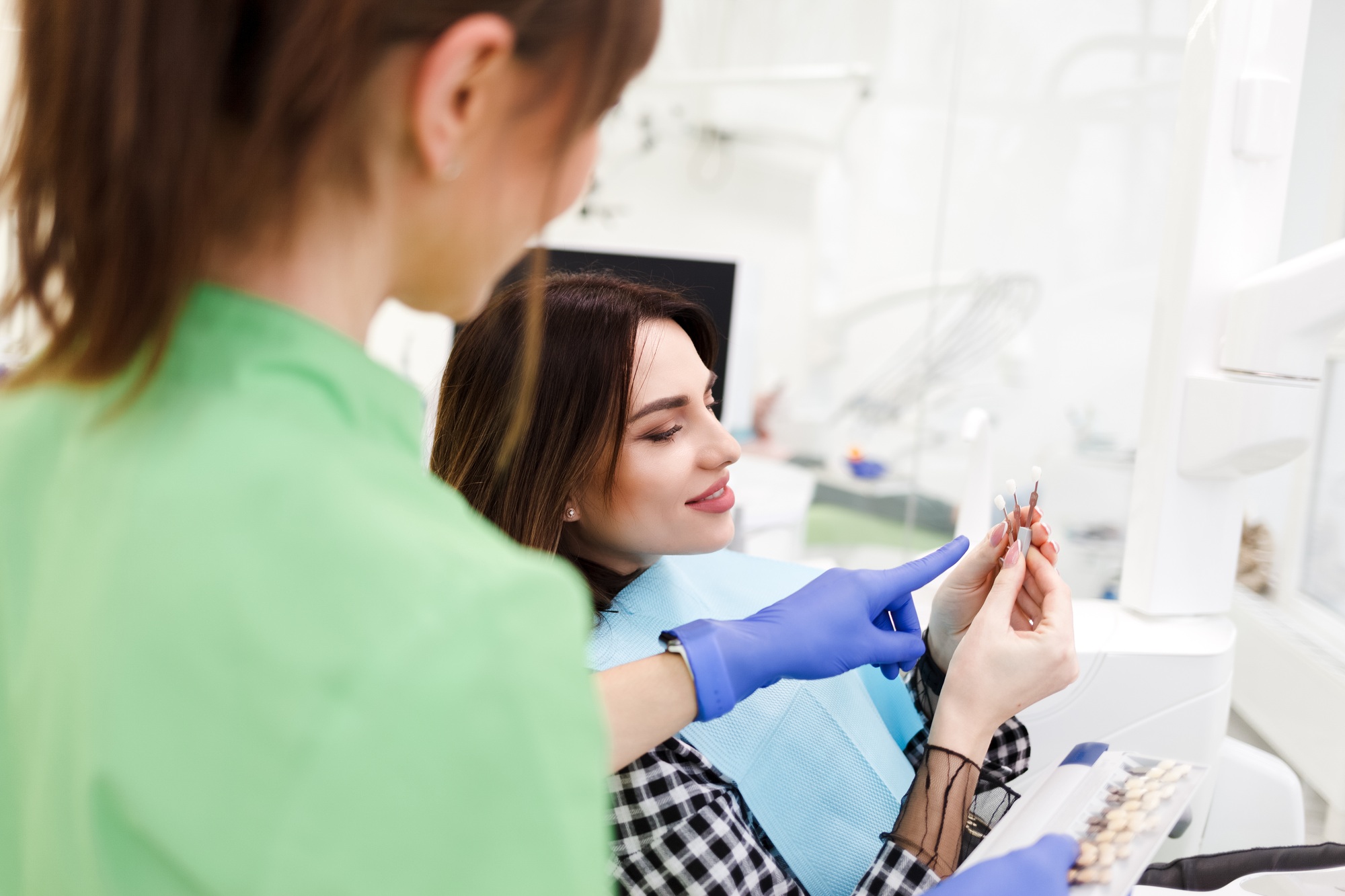 Dentist shows crown samples to his patient.