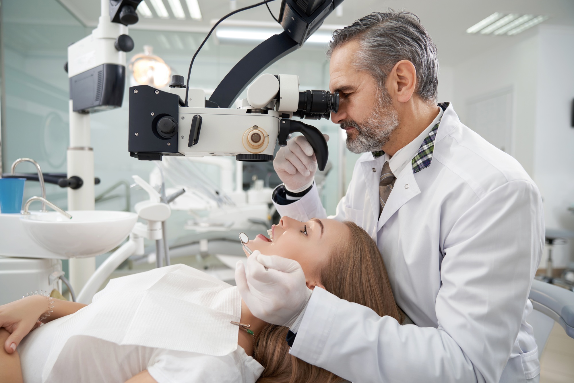 Dentist using dental microscope for examination