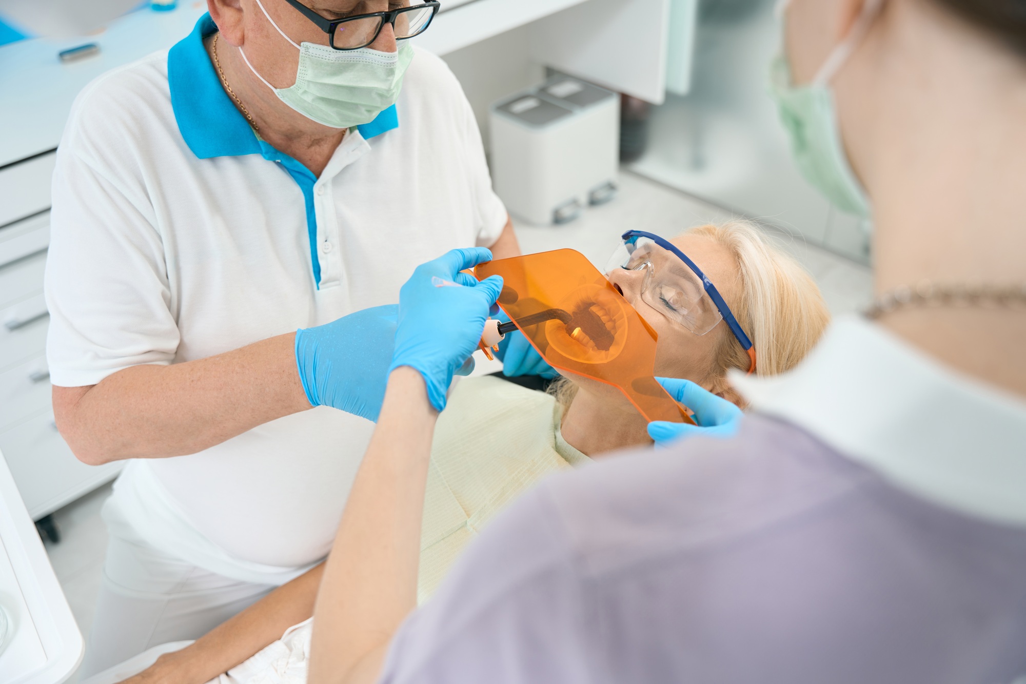 Focused stomatology team is making dental filling in medicine clinic