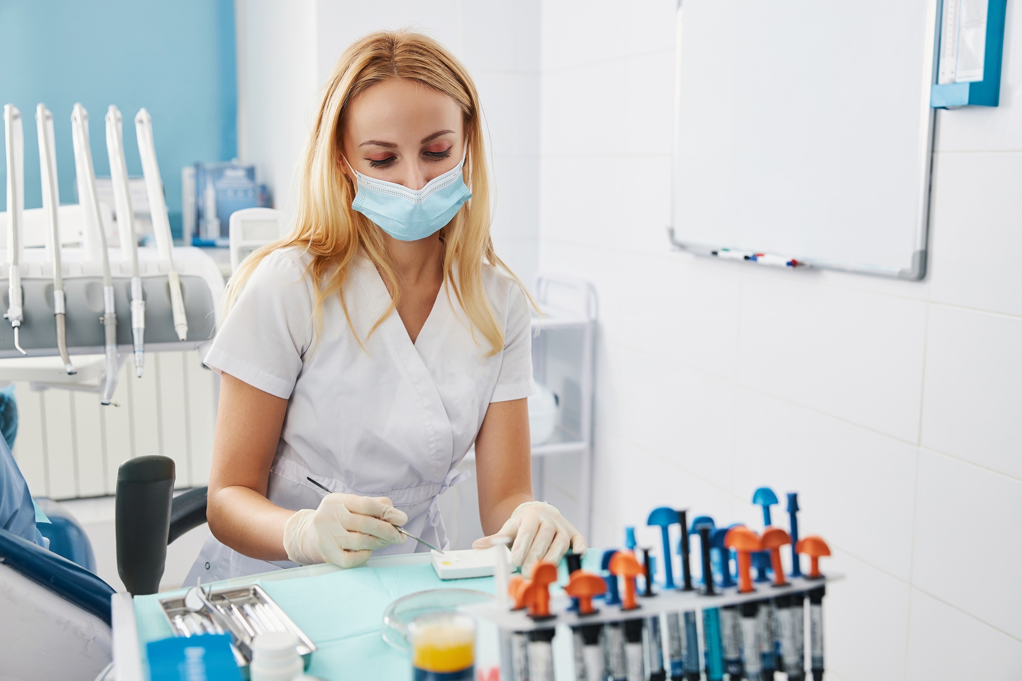 Lady in medical scrubs creating dental restoration material