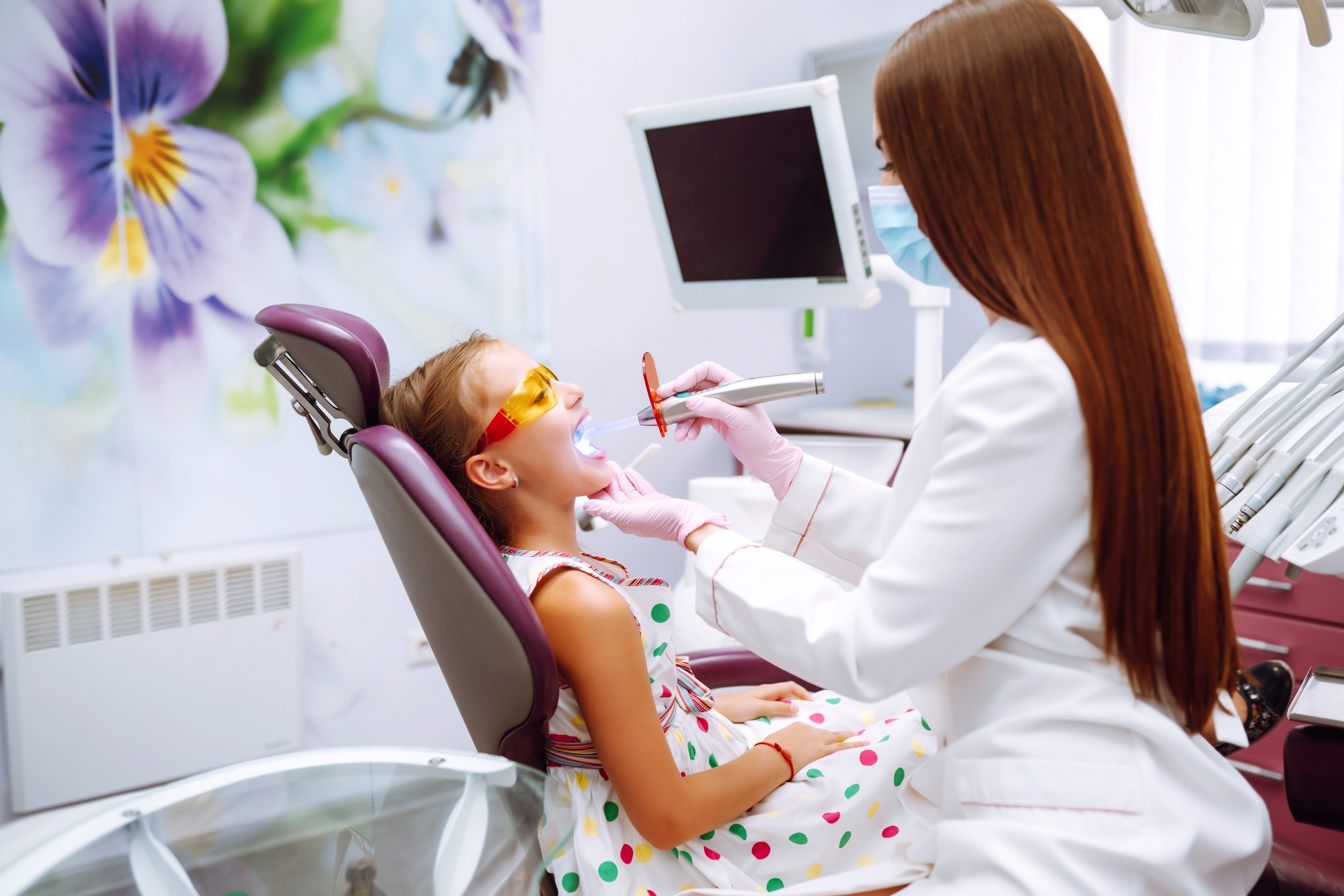 Lovely little girl smiling after doing examination in a pediatric stomatology. Milk teeth care.