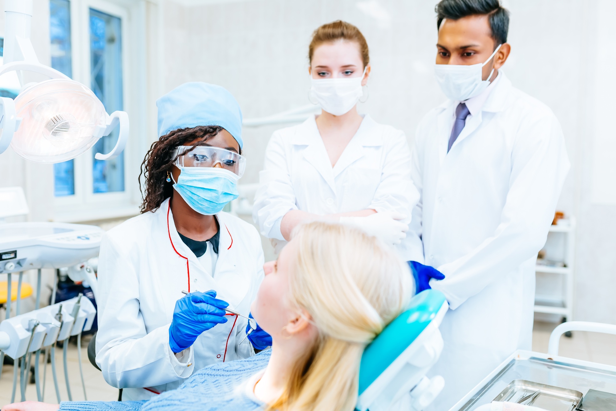 Multiracial dental team with patient in dental clinic. Dental health concept