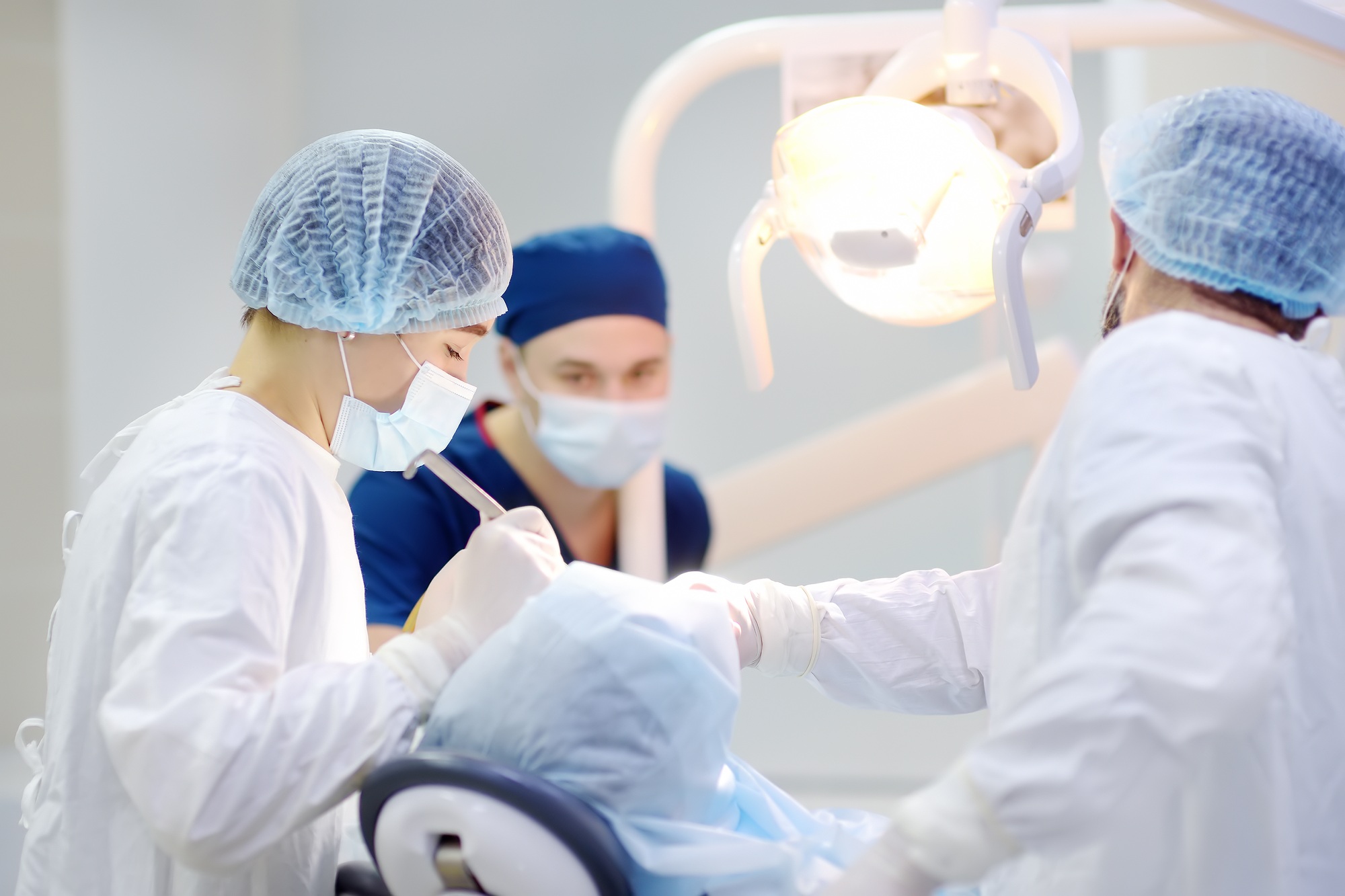 Surgeons and nurse during a dental operation.