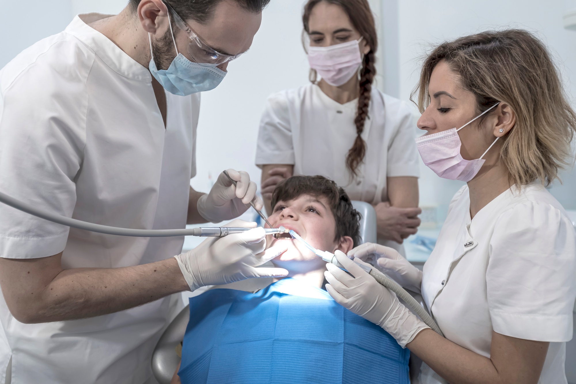 Team of dentists treating a young boy for orthodontics in the dentist's clinic