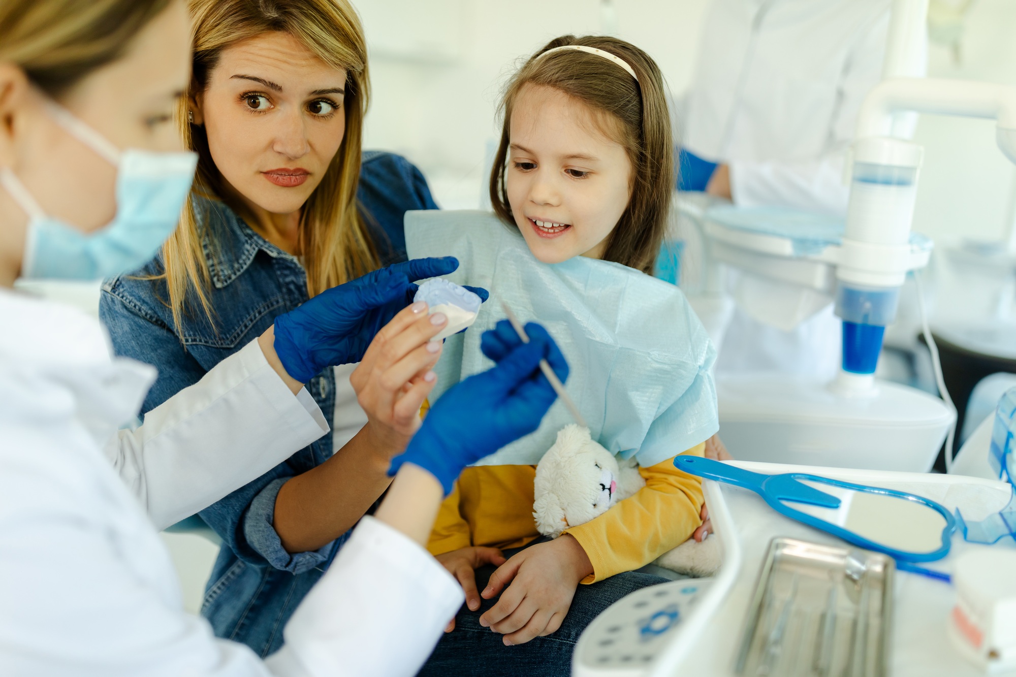 The doctor shows to little girl how to maintain the prosthesis.