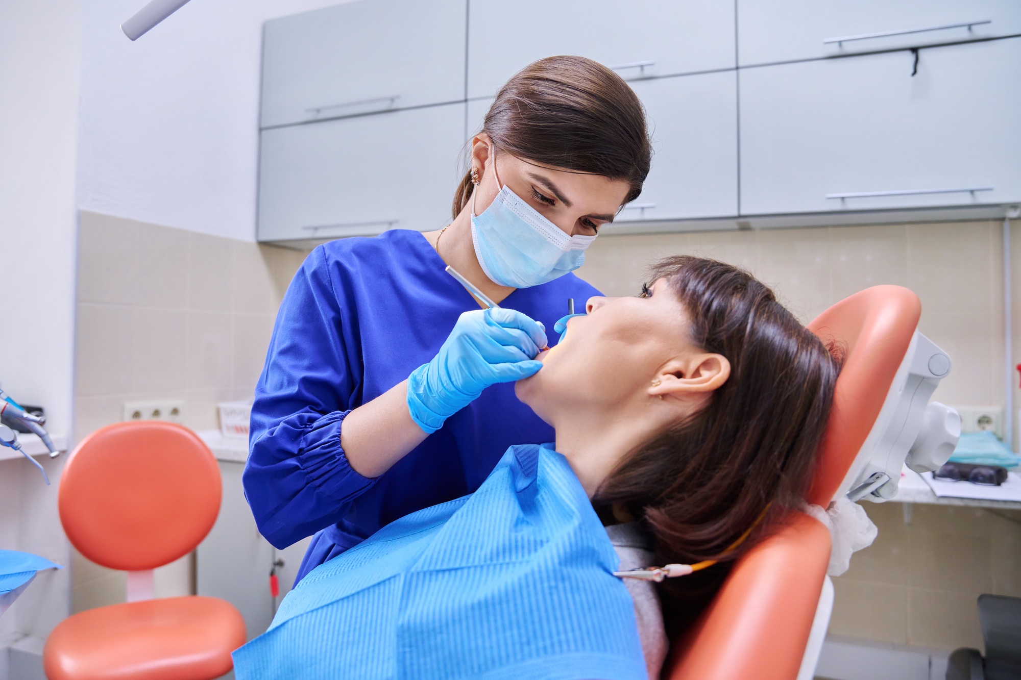Woman patient treating teeth in clinic, treatment process