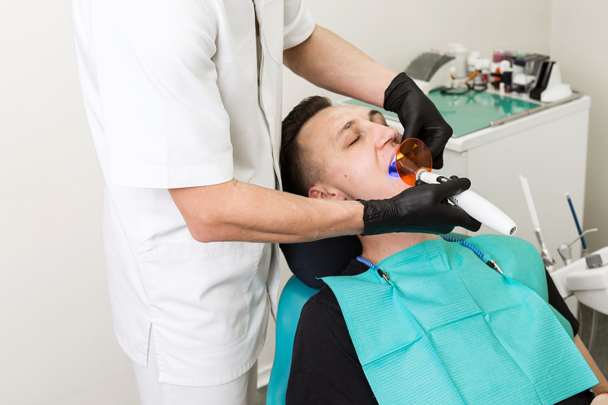 blue Dental Curing Light is used to cure the resin within a dental patient's mouth . Polymerization