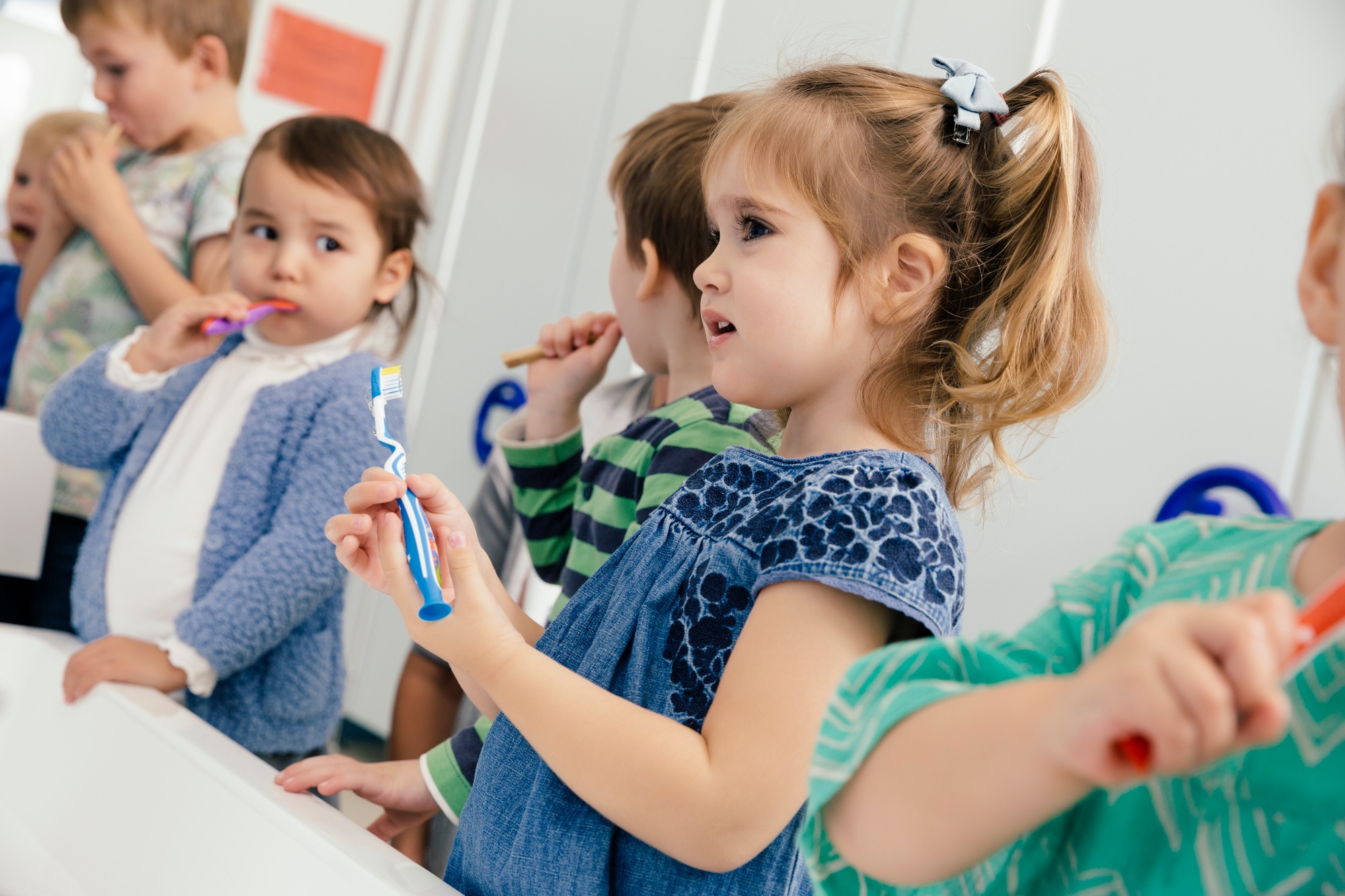 Children brushing their teeth in bathroom of a kindergarten