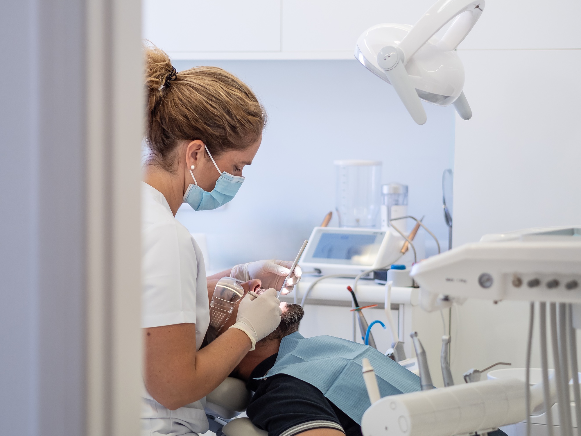Dental hygienist performs cleaning procedure on patient at clinic