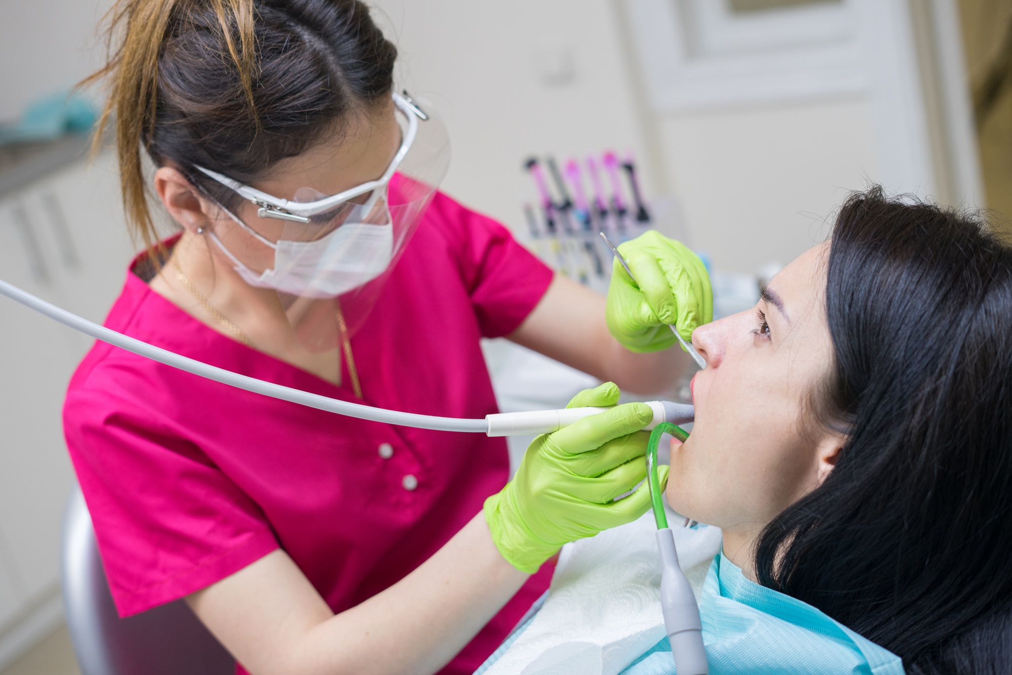 dentist cleaning teeth of woman