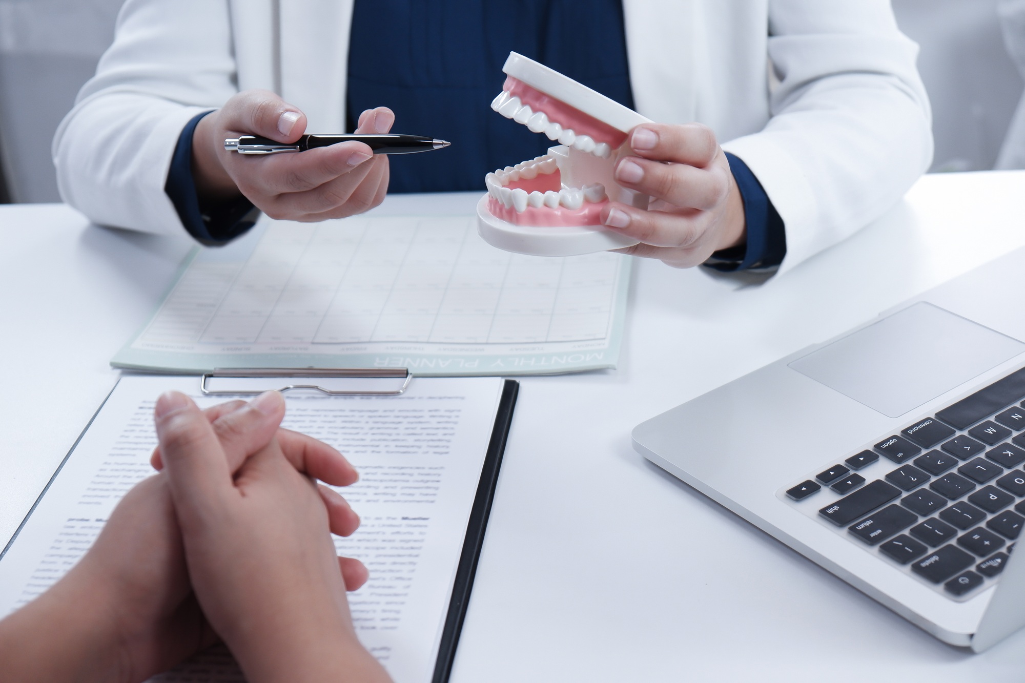 Dentist explaining process of treatment to patience, medical health concept.