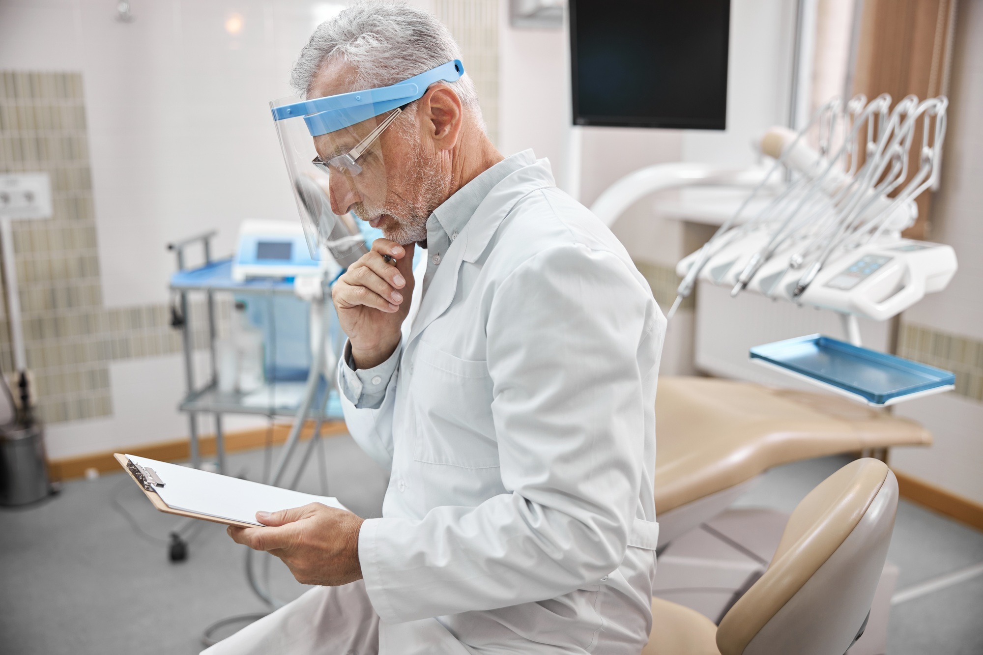 Elderly dentist checking his schedule of appointments