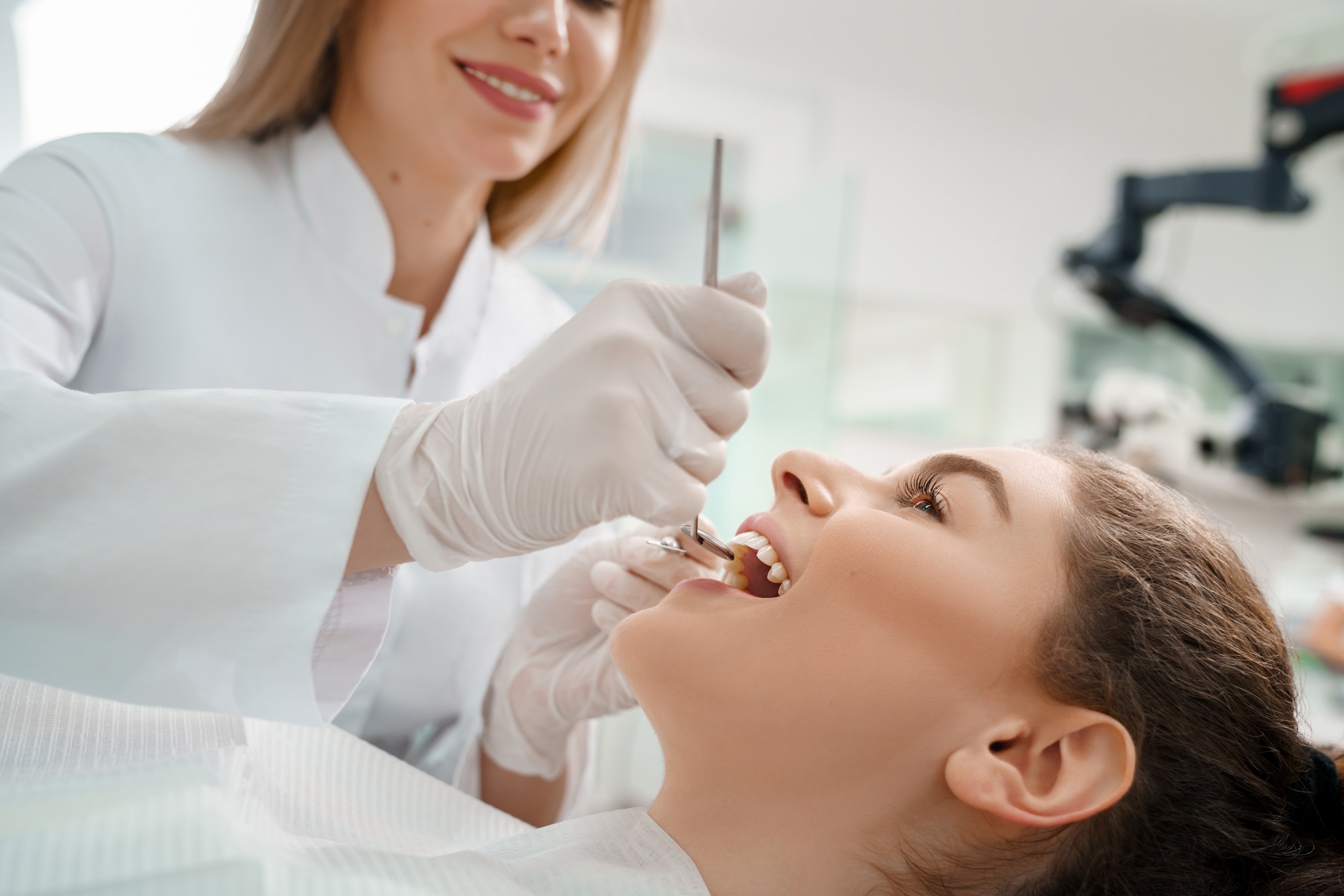 Happy woman curing teeth in dentistry.