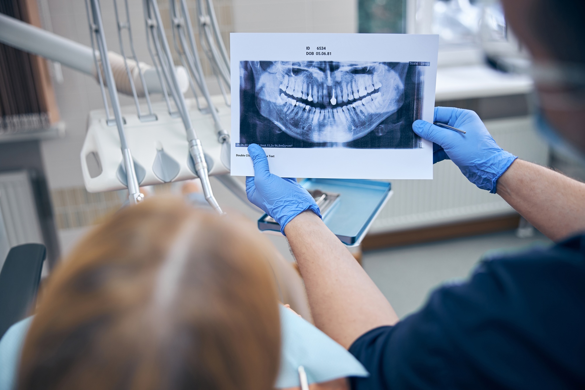 Male dentist discussing x-ray with patient in office