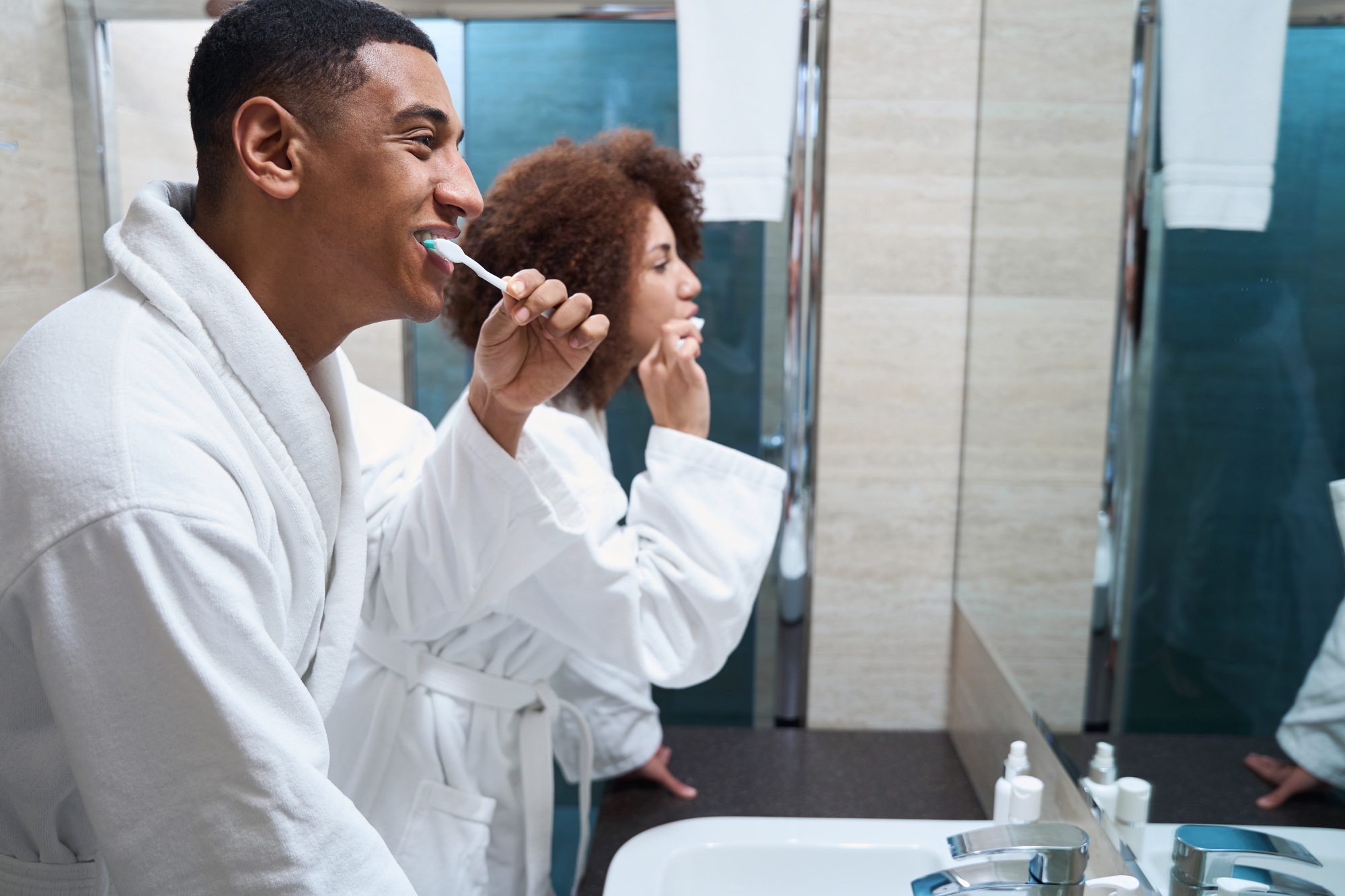 Man and a woman brush their teeth in the bathroom