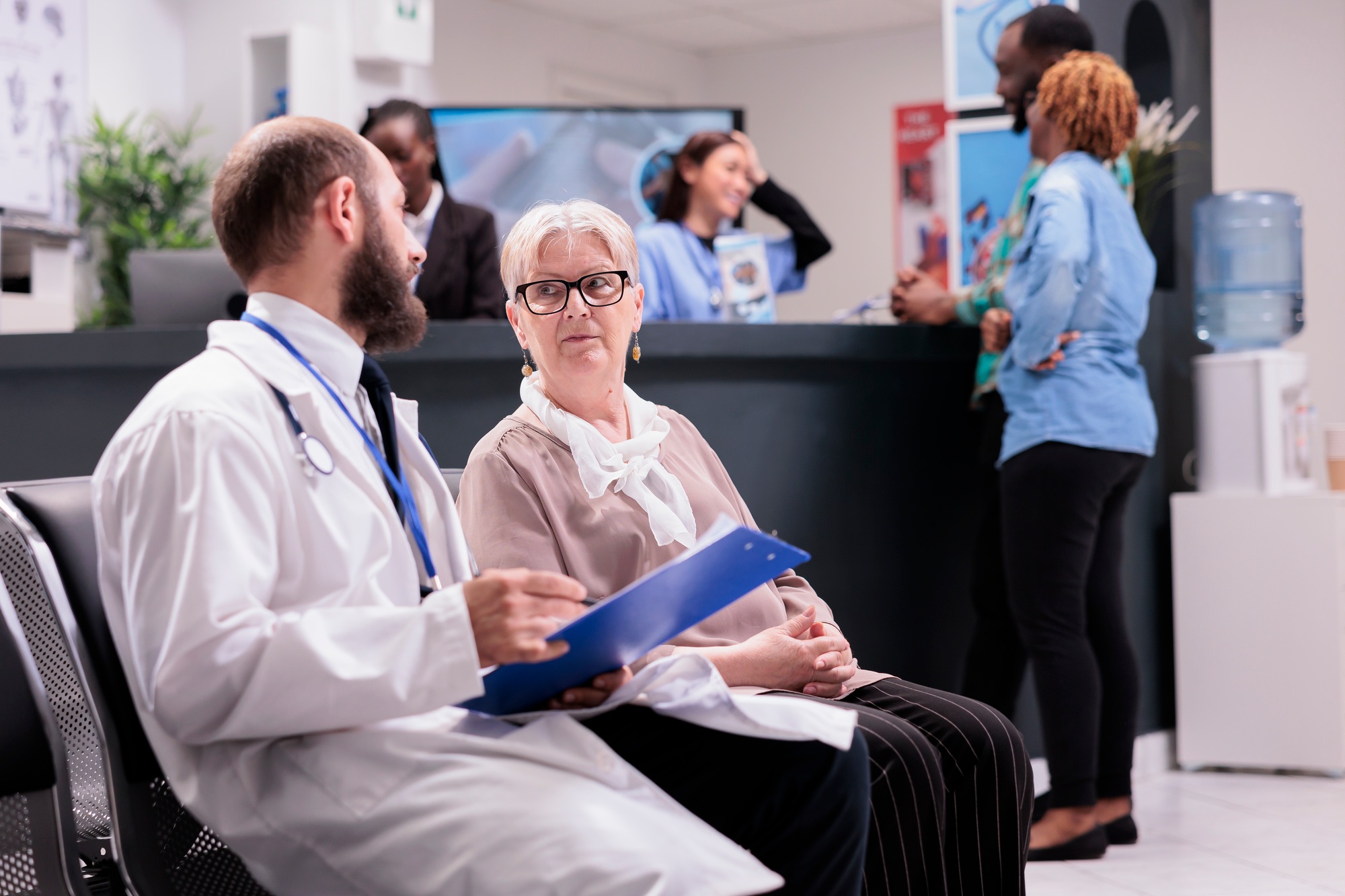 Physician of hospital interviewing old woman