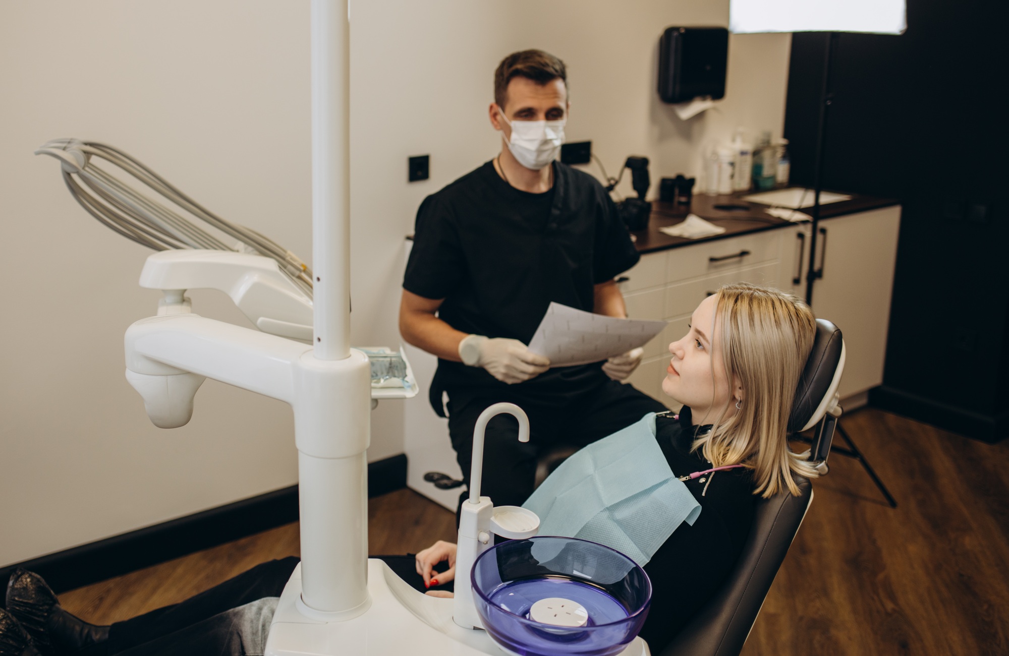 Teenage girl with dental braces visiting orthodontist at dentist's office.